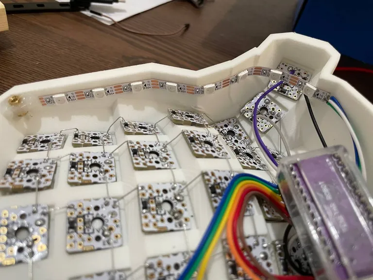 Amoeba PCBs seated in the key wells and chained with thin wire, LED strip around the rim