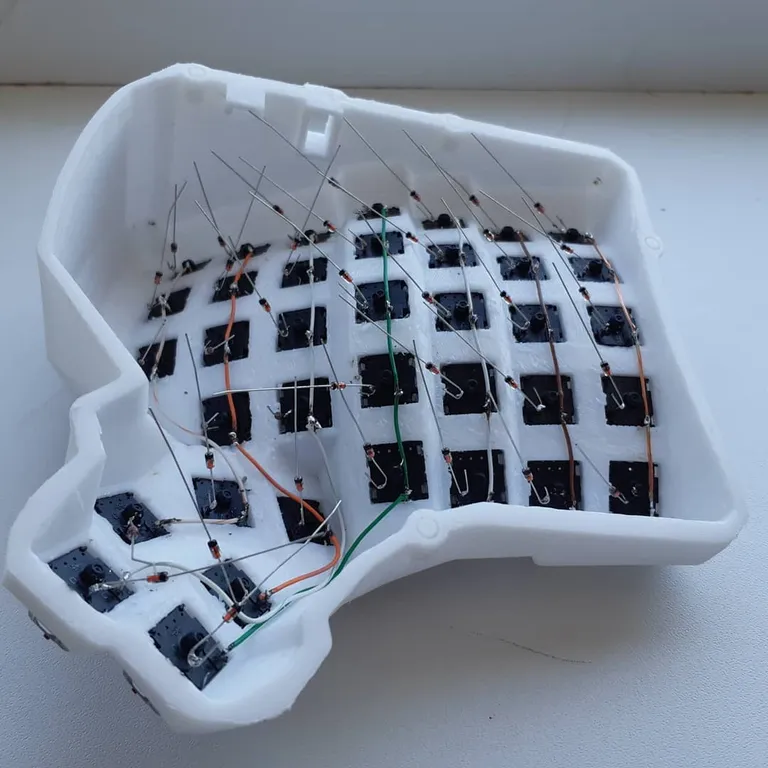 Diodes soldered to each switch with their legs still sticking straight up, before bending into rows
